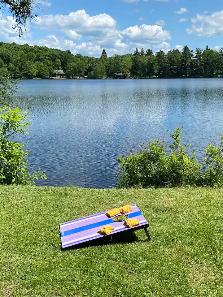 Cornhole set up on the grass with Shehawken Lake behind