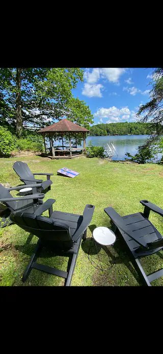 Adirondack chairs by the lake with gazebo and dock view