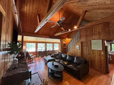 The great room at Shehawken Lake Cabin with the fireplace and lake-facing windows, the center of a Christmas week stay
